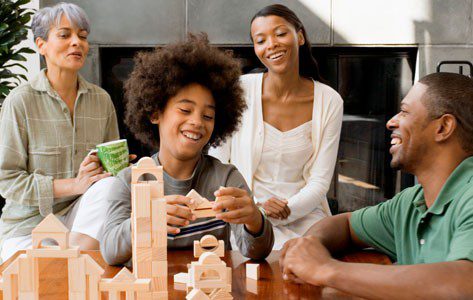Family watches child build with blocks