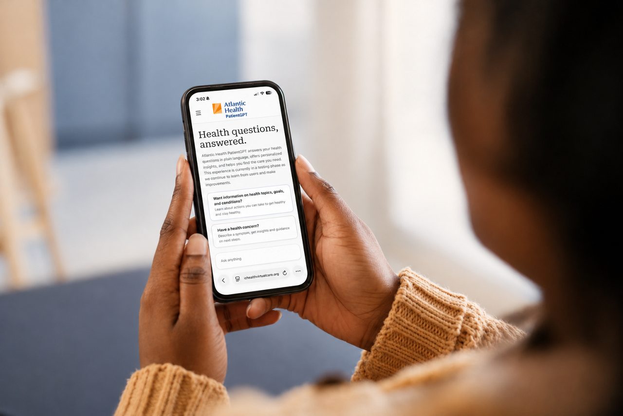 A woman uses Atlantic Health PatientGPT to ask a health question on her couch.