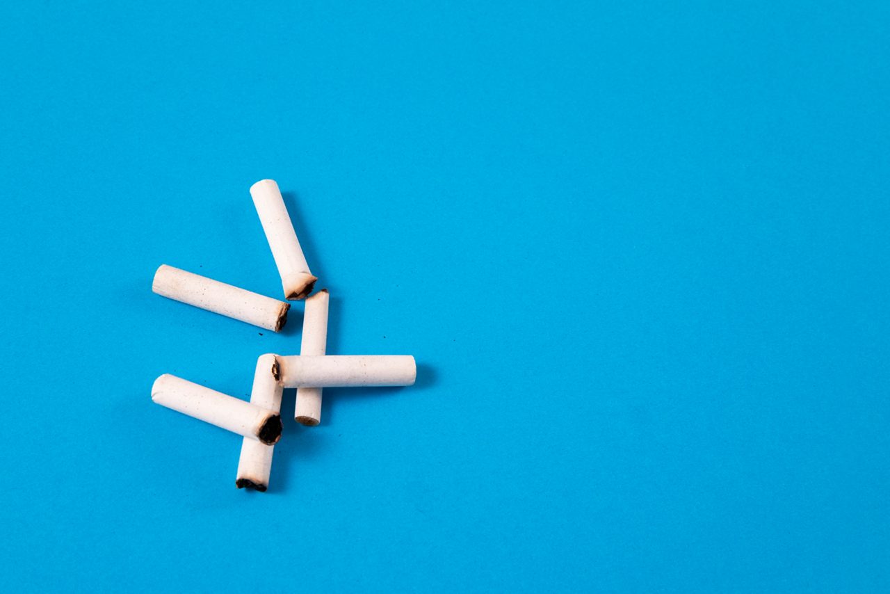 Cigarette butts on blue background