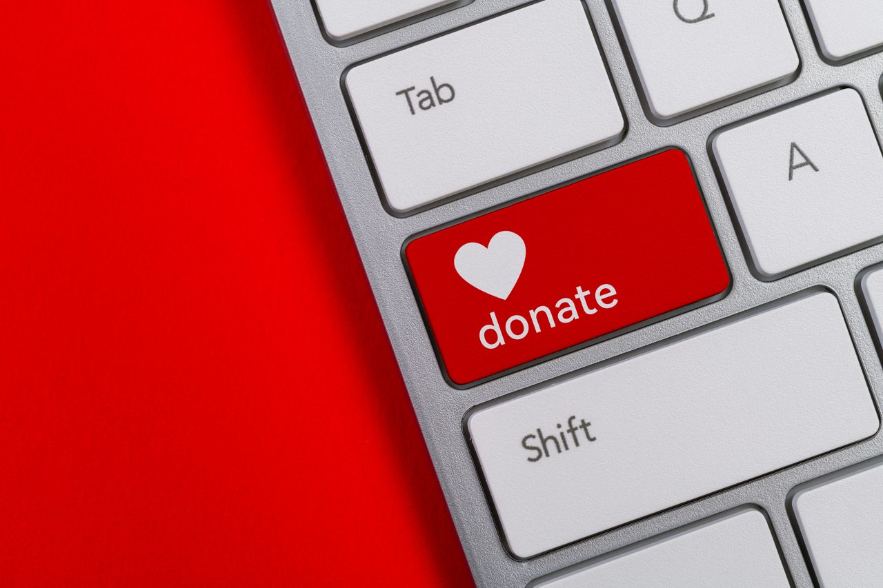 Computer keyboard with word donate and heart icon