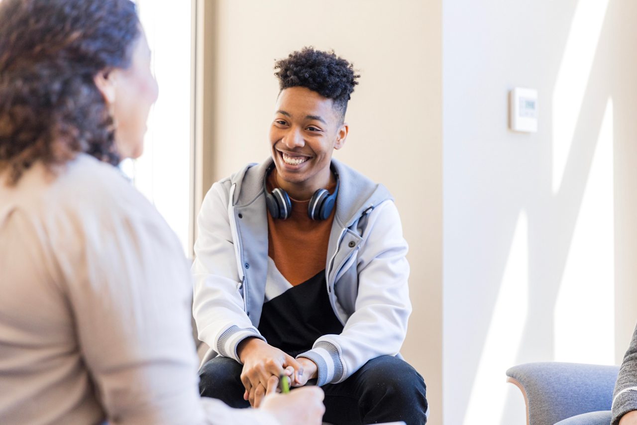 Confident young man and mature woman talking during therapy session.  Mental health, emotional support.