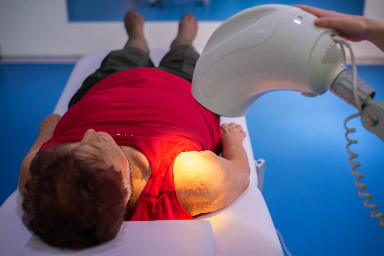 Senior woman receiving heat therapy for her shoulder.