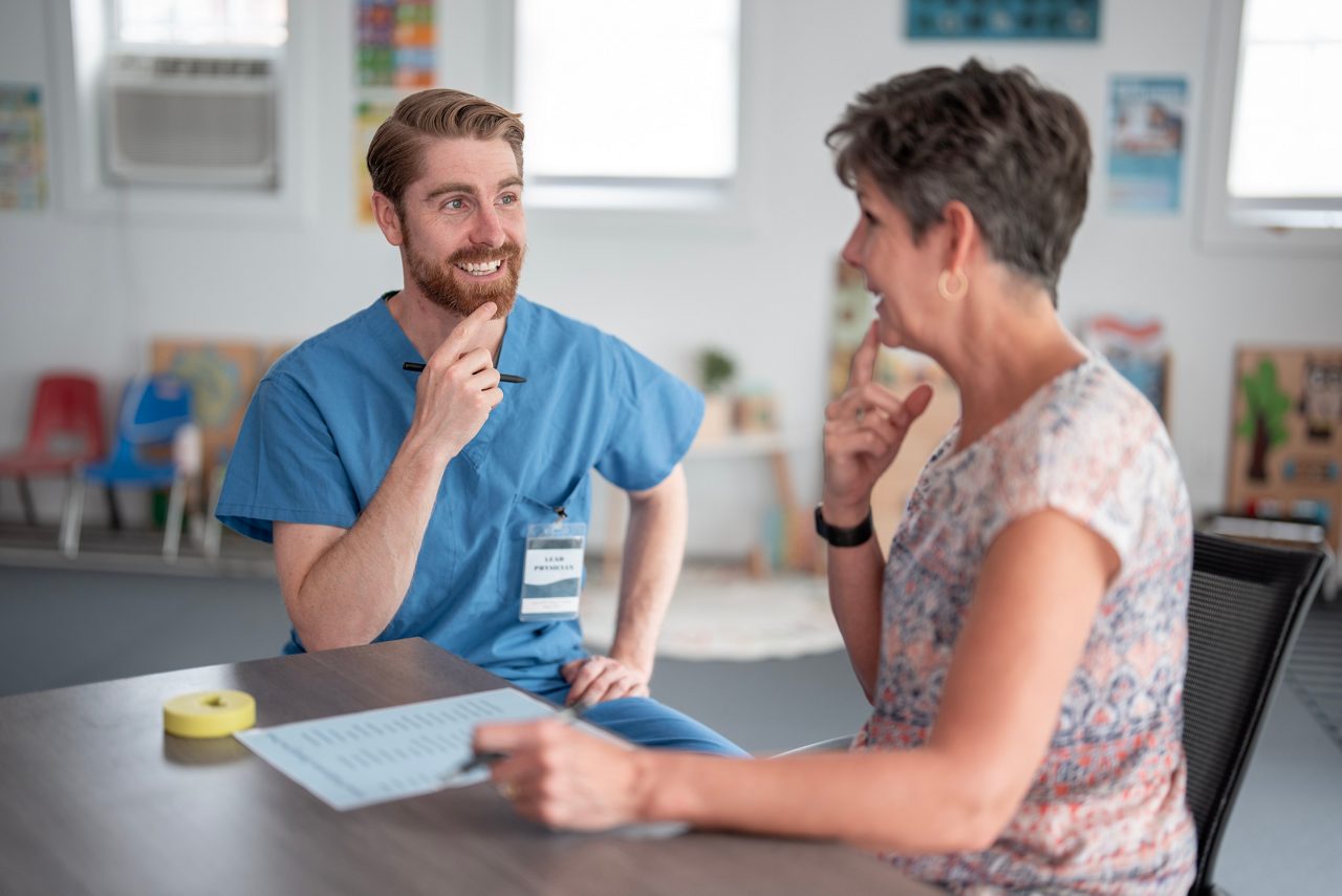 A professional therapist interacts with a patient during a speech therapy session.