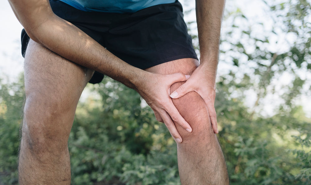 Man holding his knee.