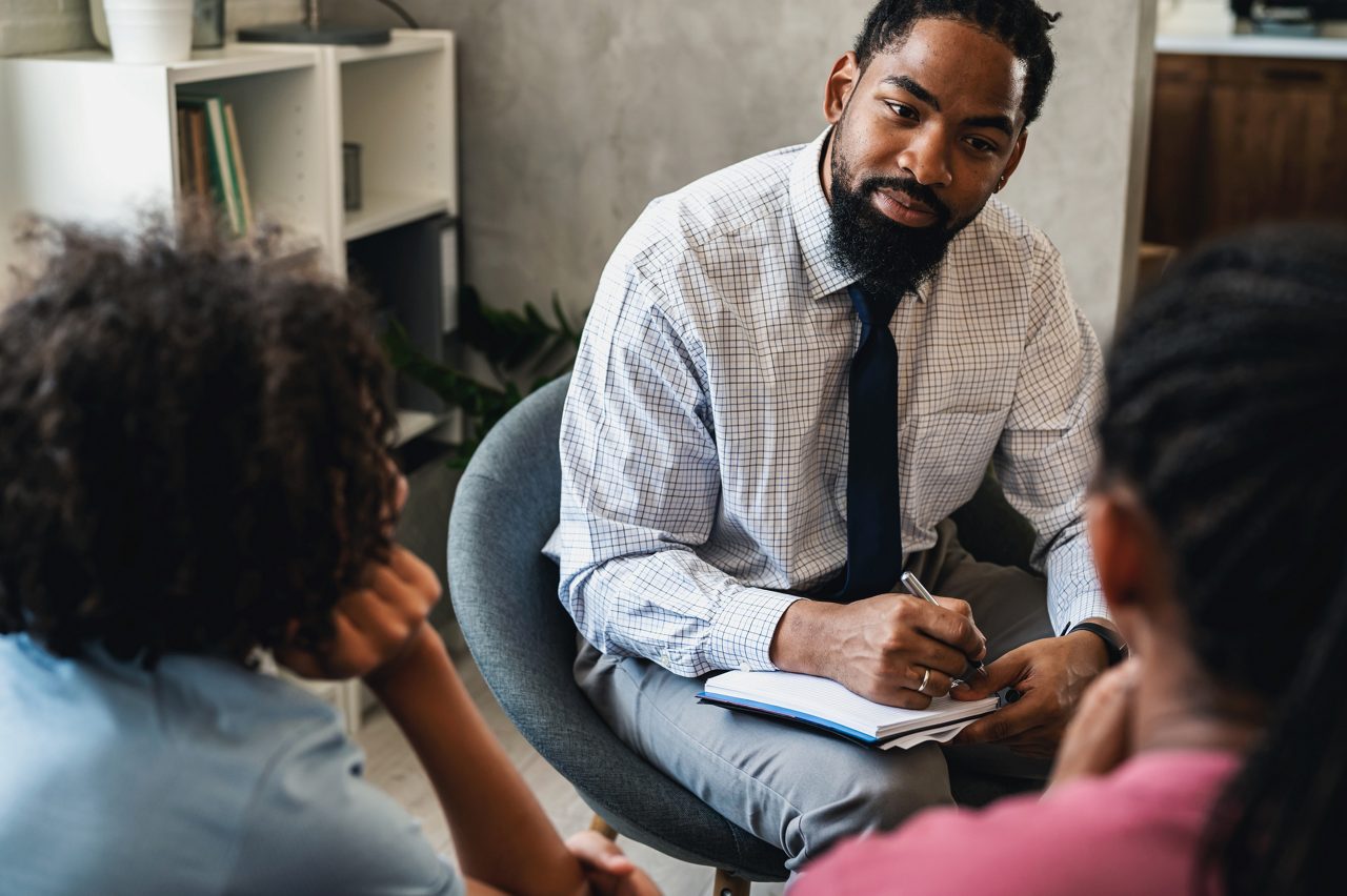 African American woman with teen son have a meeting with psychologist. A psychotherapist session with a patient. mother seeks professional help for her teenage son