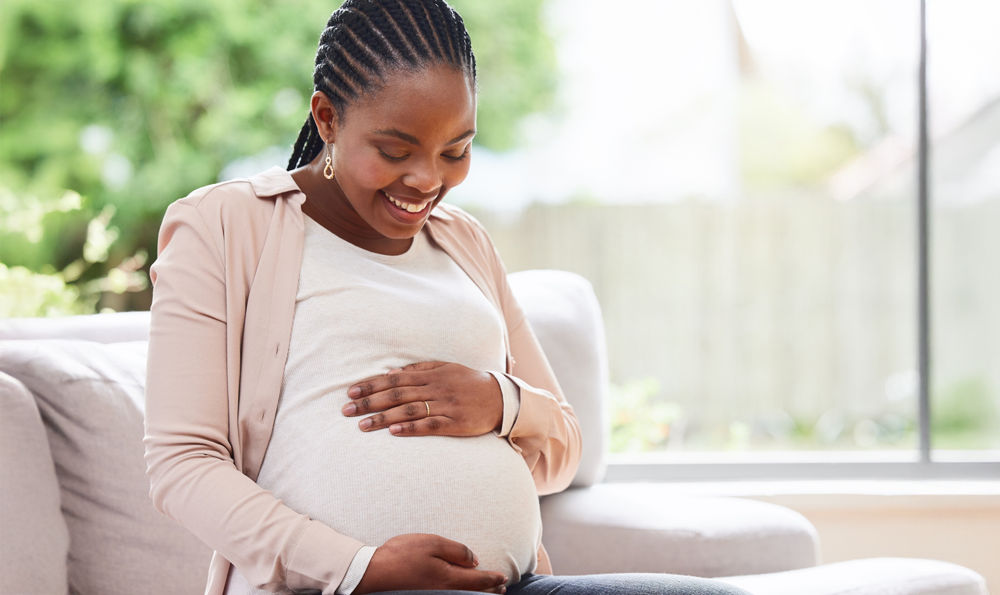 A smiling black pregnant woman