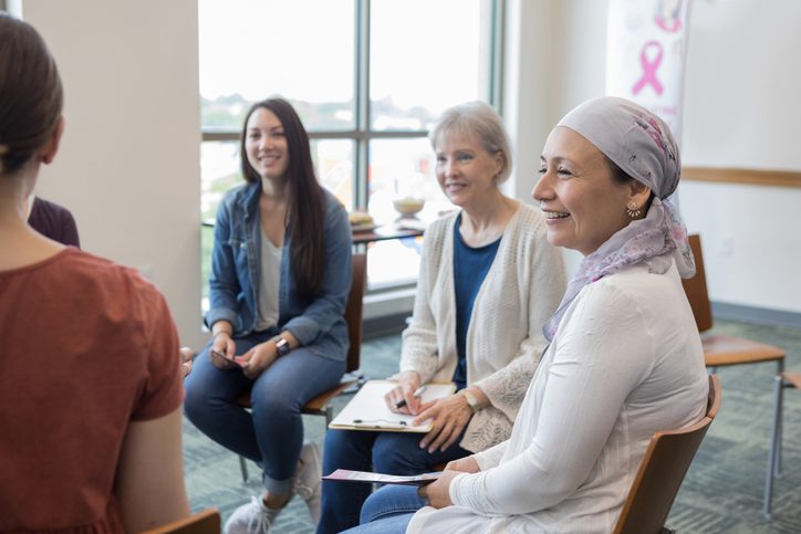 Women in a cancer support group session are shown.