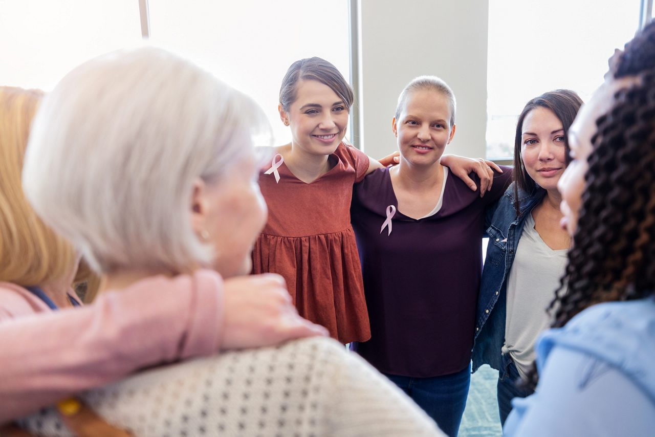 A cancer support group with their arms around each other. 