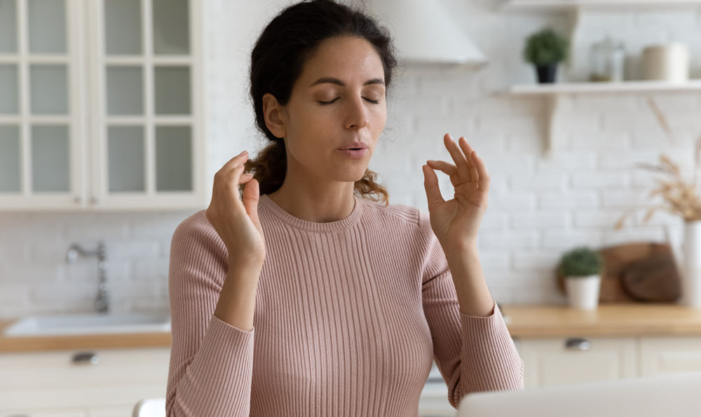 Woman practices mindfulness in her kitchen.