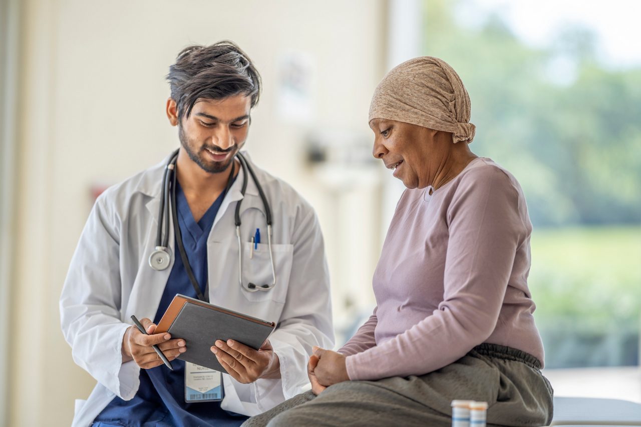 Oncologist sitting and talking to a patient.