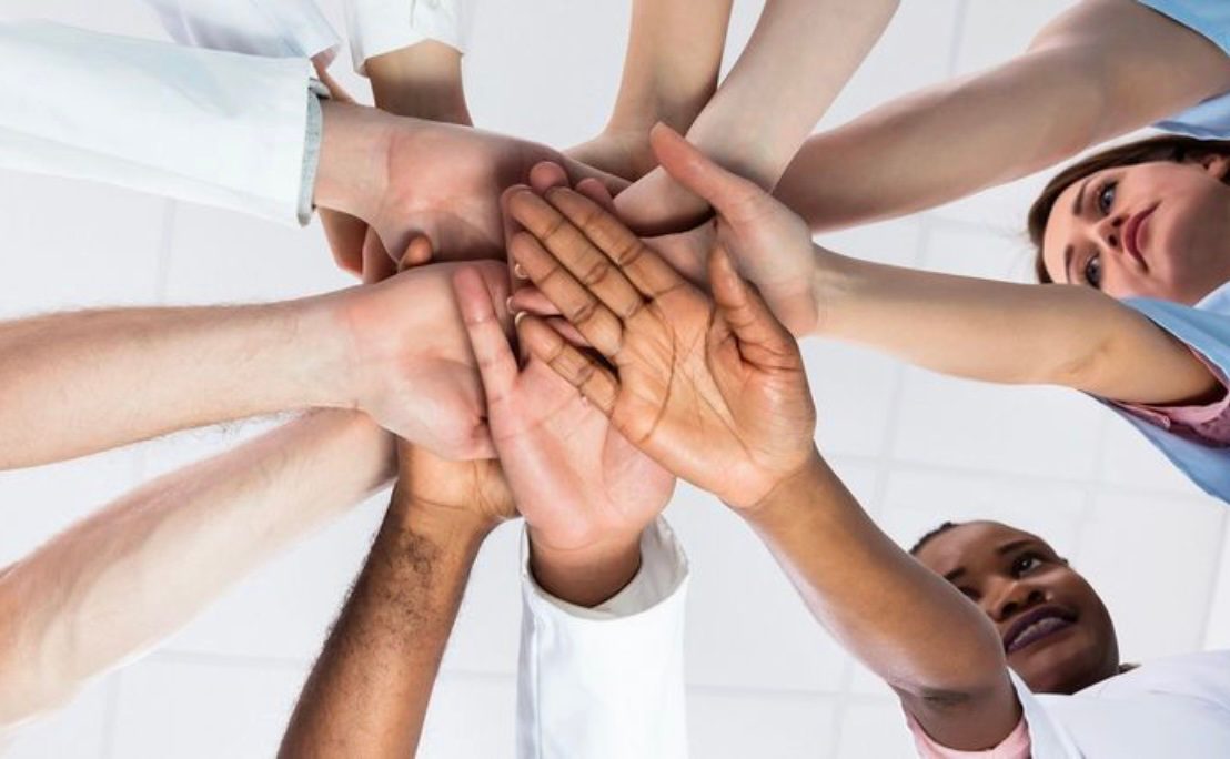 A team putting their hands together.