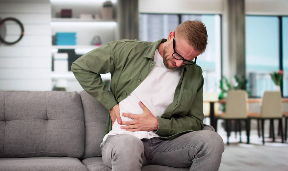 A man in pain holding his torso.