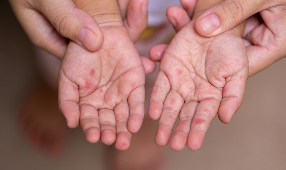 A parent holding a child's hands.