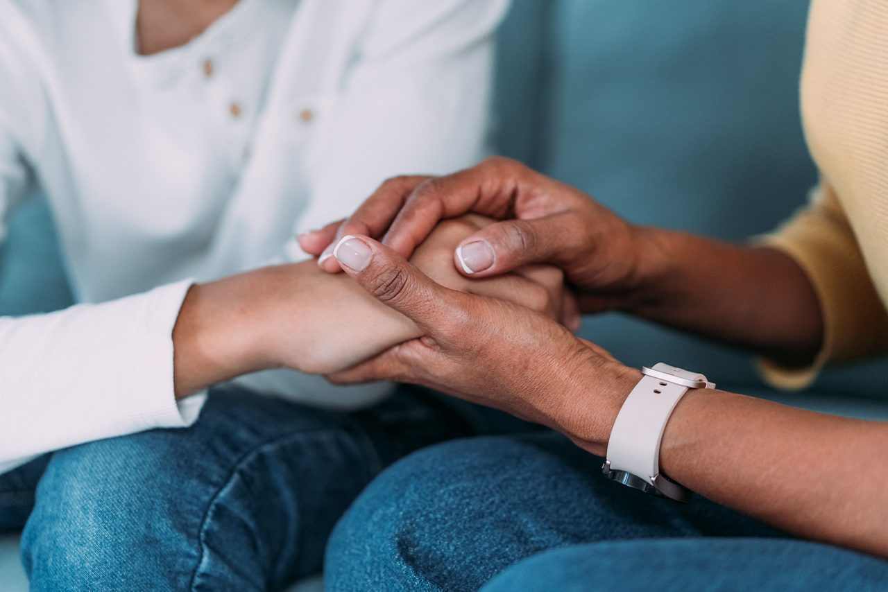 Therapist holding a child's hand.