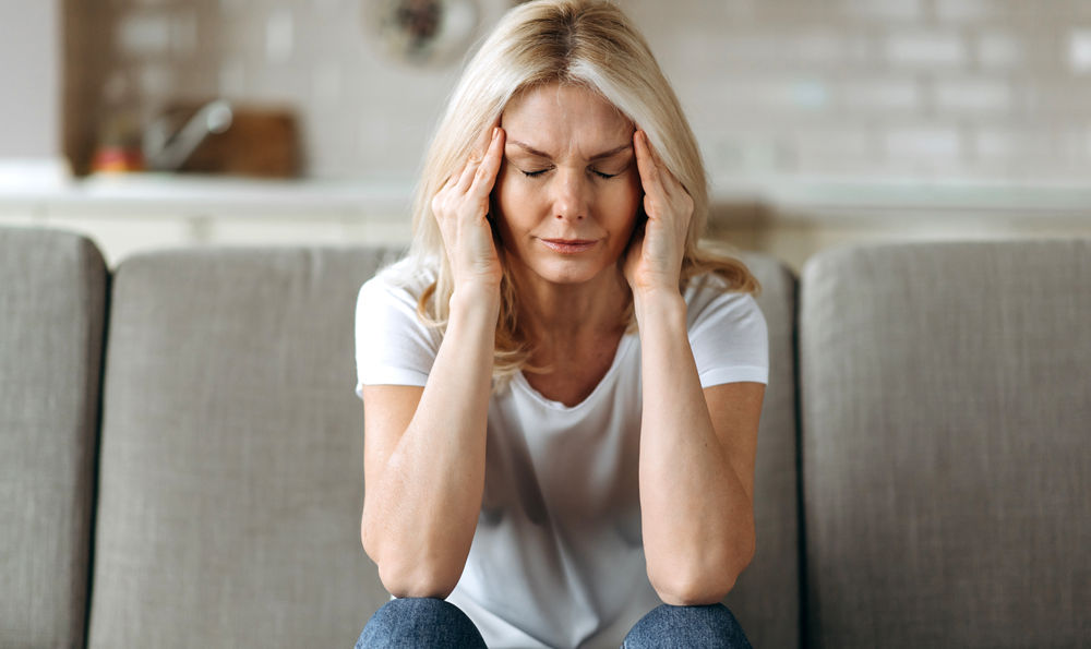 A woman with a headache holding her head