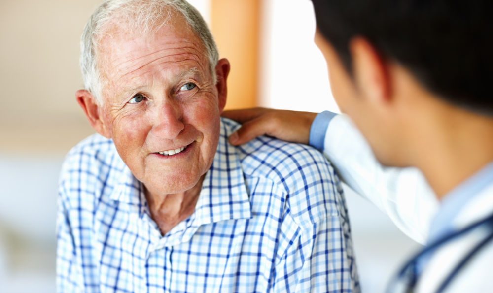 Senior man smiling at a doctor.