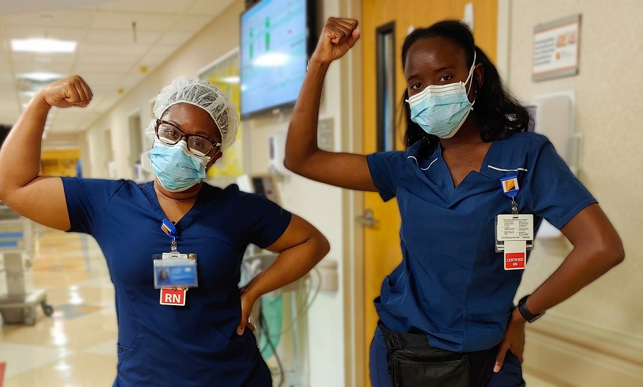 Two nurses flexing their muscles.