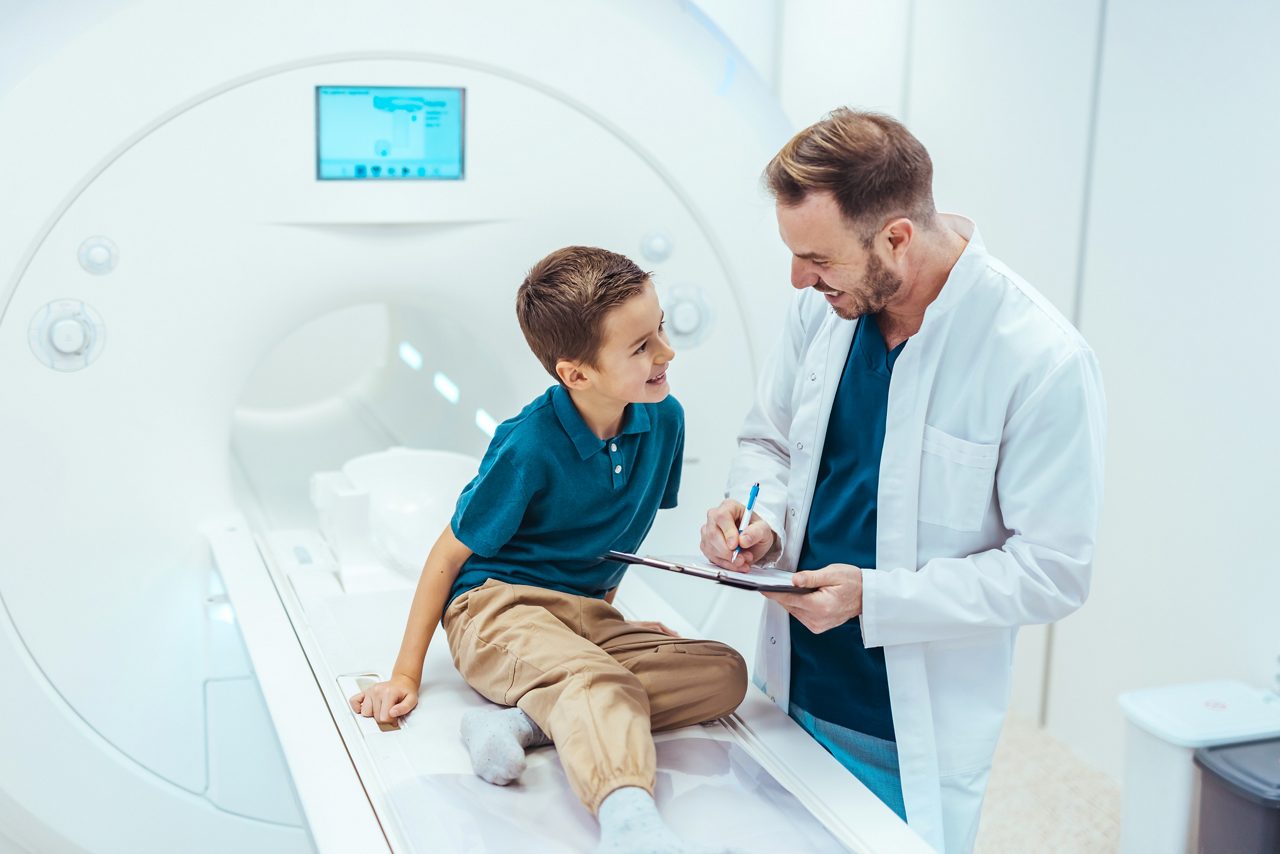 Medical professional smiling at child after MRI.