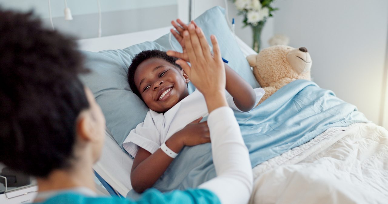 Nurse giving a high five to a pediatric patient.