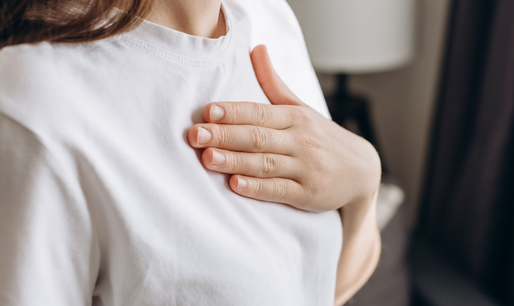 Women suffering from reflux rubs her sternum.