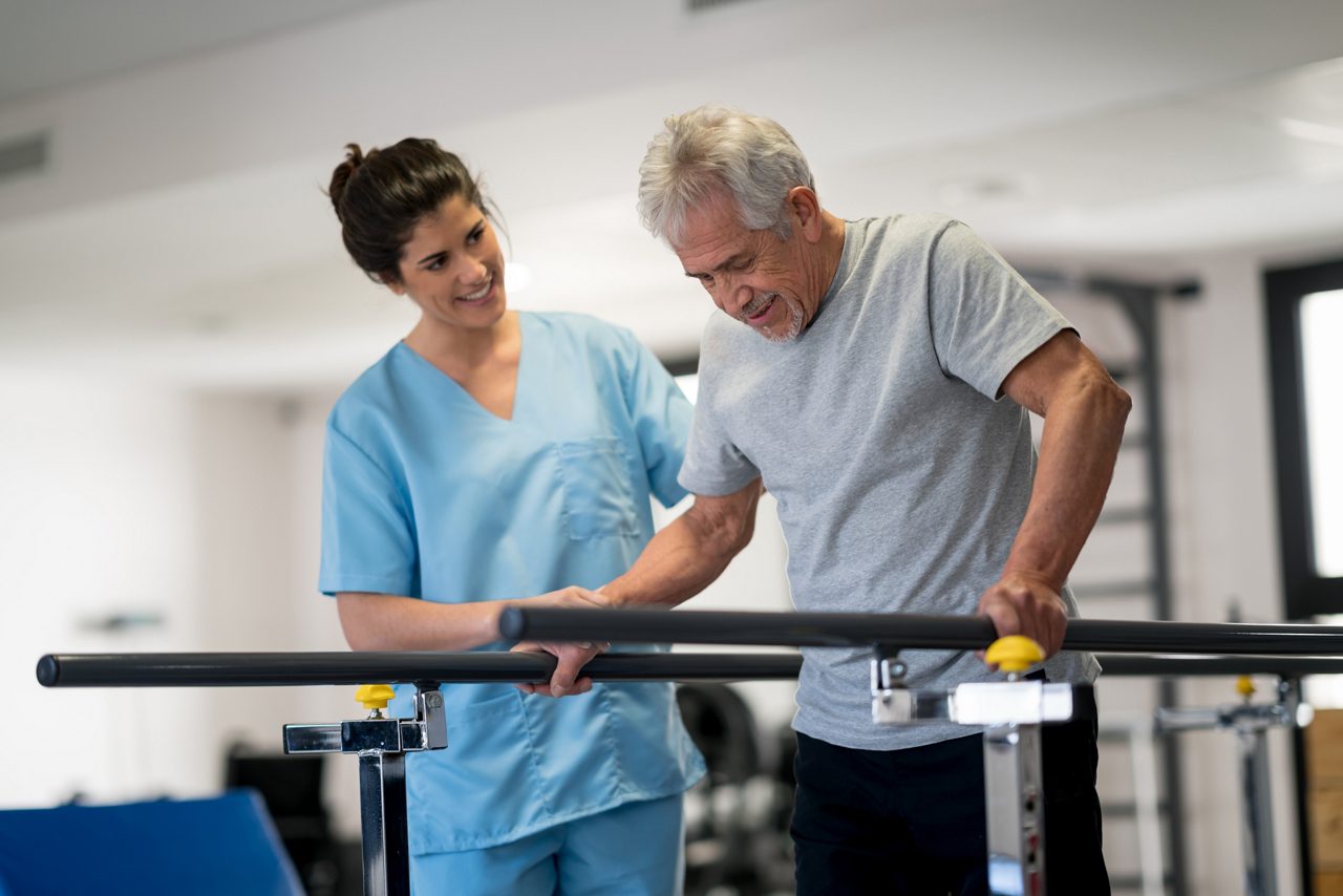 Therapist helping a stroke rehabilitation patient walk.