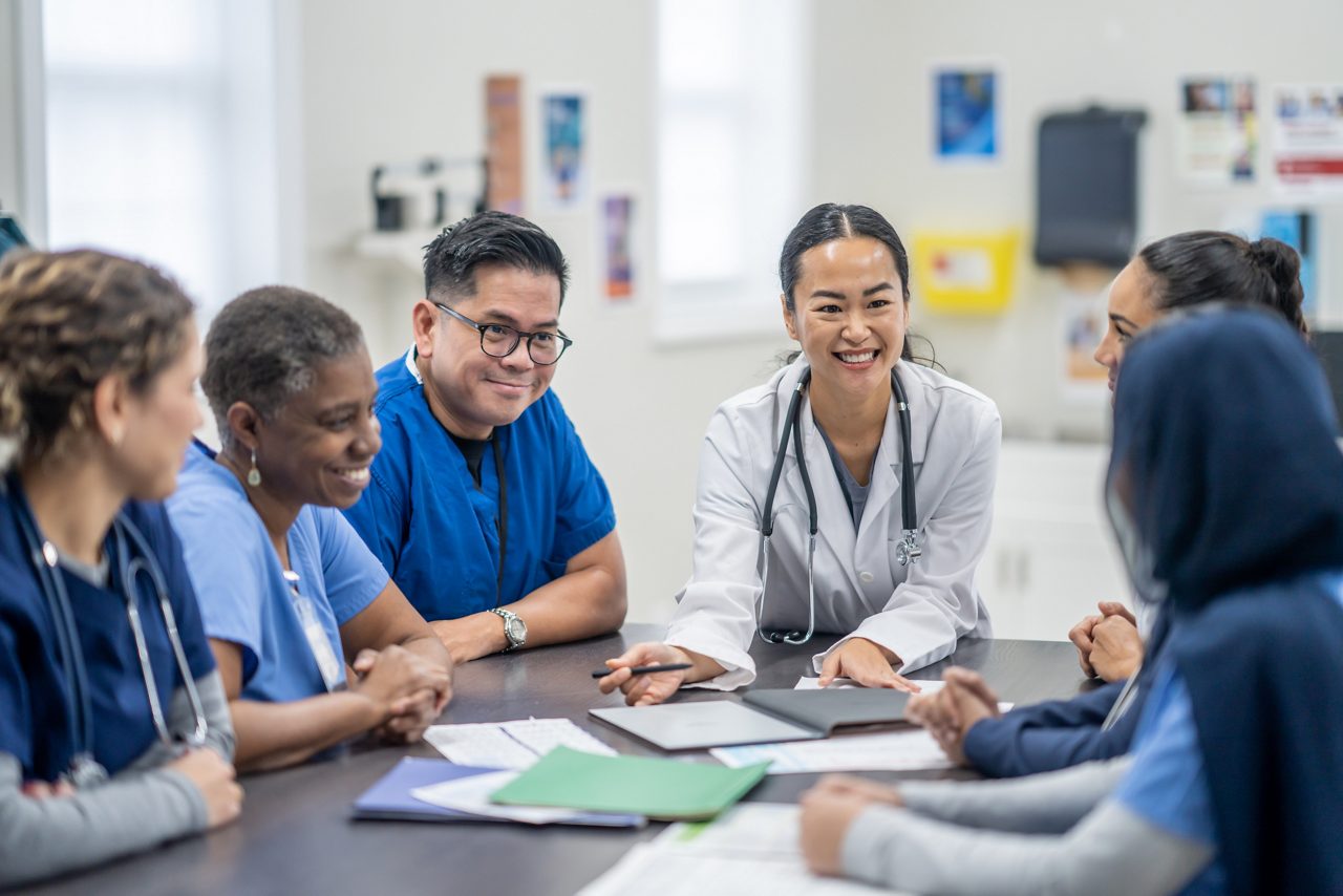 A group of health care professionals smiling at a table.
