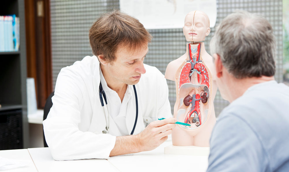 A urologist discusses incontinence with a mature man.