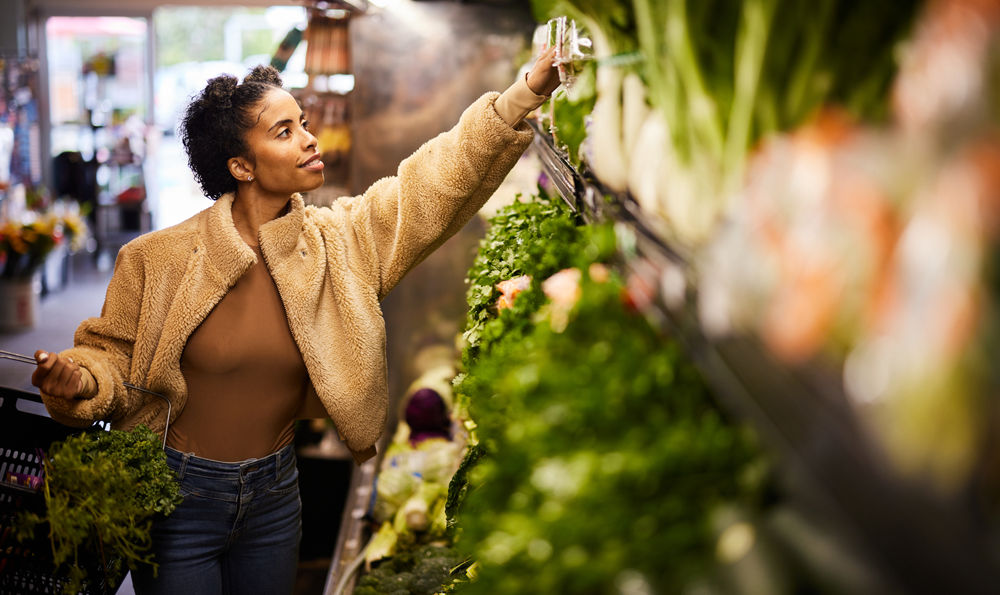 A woman picking vegetables in a market